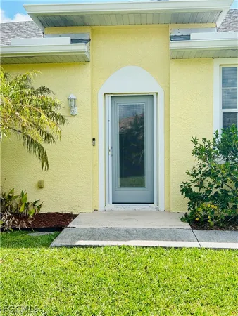 a view of an empty room with window and chandelier fan