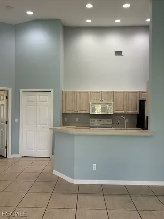 a view of an empty room with a chandelier fan