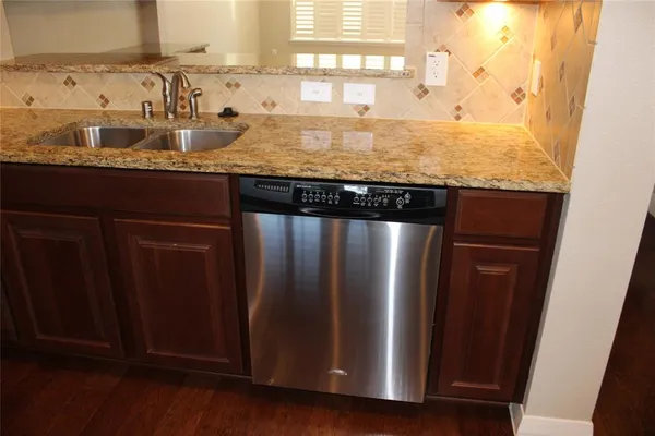 a kitchen with granite countertop wooden cabinets and a refrigerator
