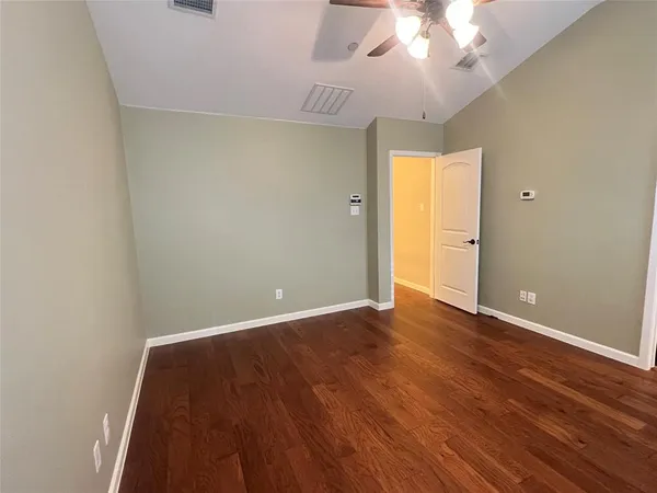 a view of a room with wooden floor and a ceiling fan