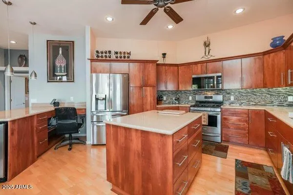 a kitchen with stainless steel appliances granite countertop a refrigerator a sink dishwasher a stove top oven a refrigerator and cabinets