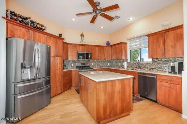 a kitchen that has a lot of cabinets a sink and a refrigerator in it