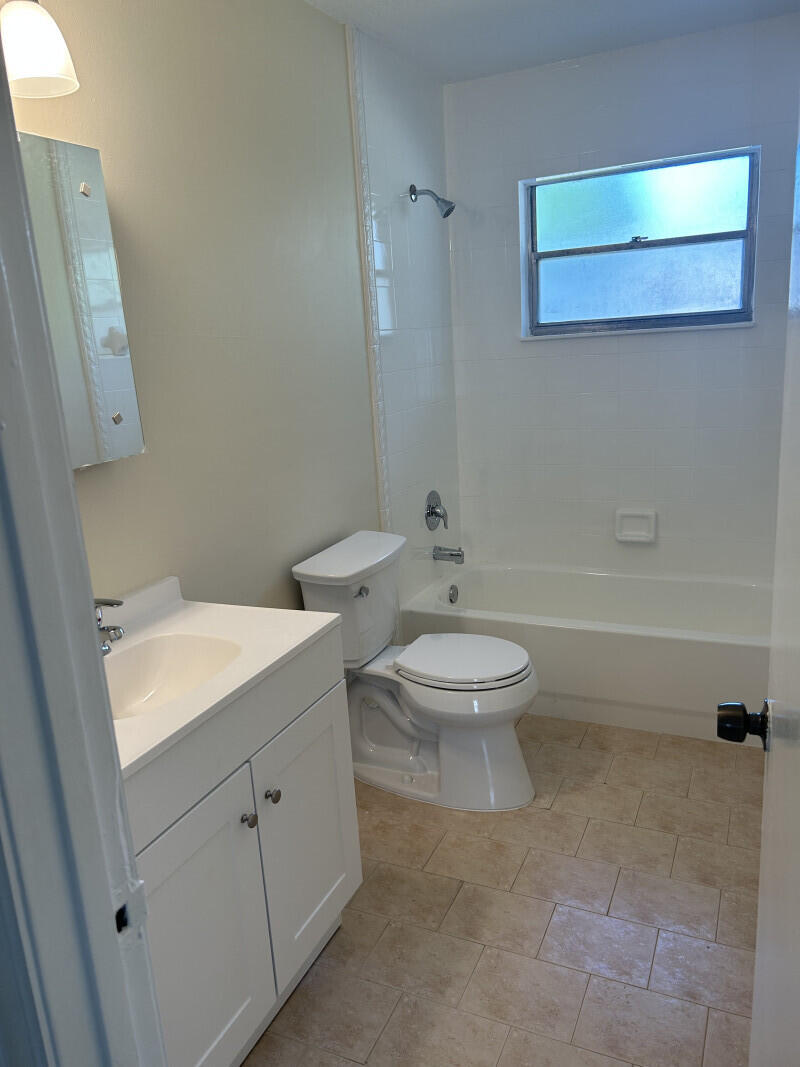 6793 4th Street Jupiter, FL 33458 - Photo 11 of 14 a bathroom with a toilet a sink and mirror