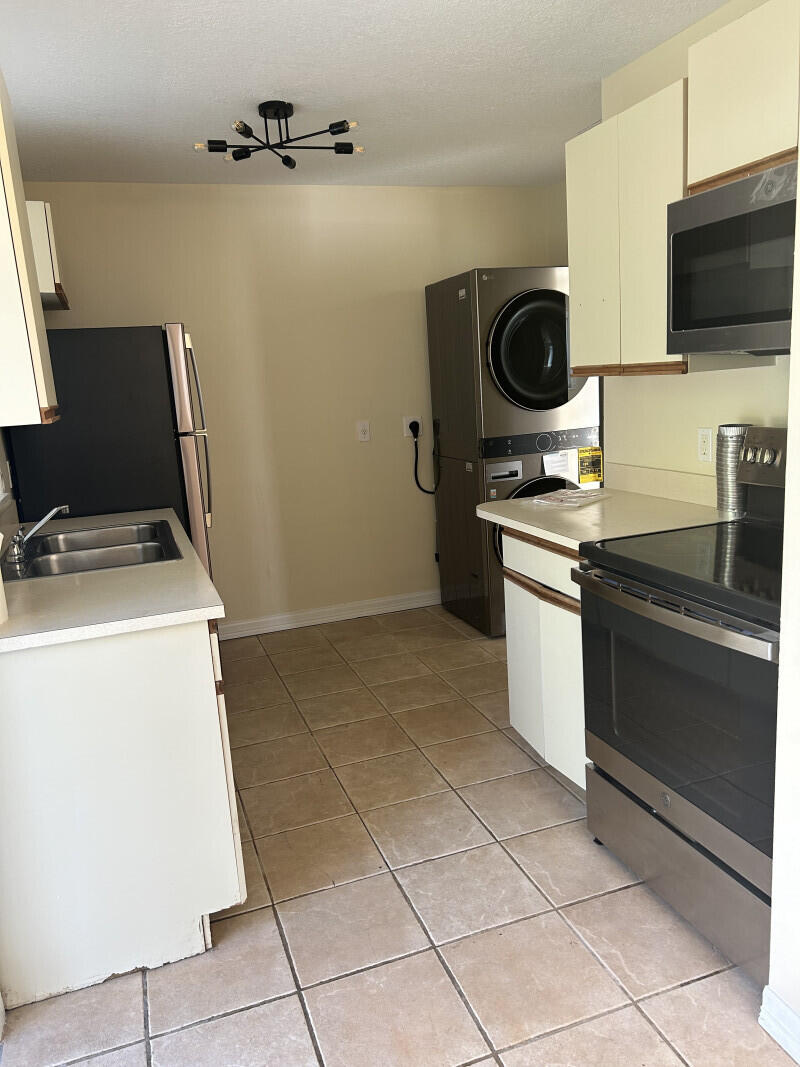 6793 4th Street Jupiter, FL 33458 - Photo 3 of 14 a kitchen with a sink and a stove top oven