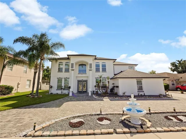 a view of a white house with a yard and plants