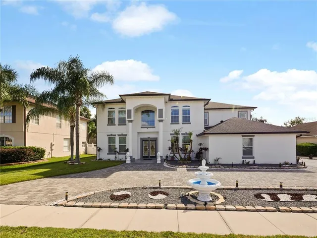 a view of a white house with a yard and plants
