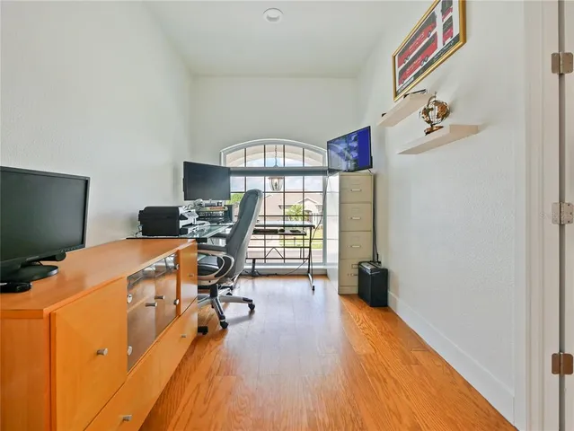 a spacious bedroom with a bed a chair and a chandelier