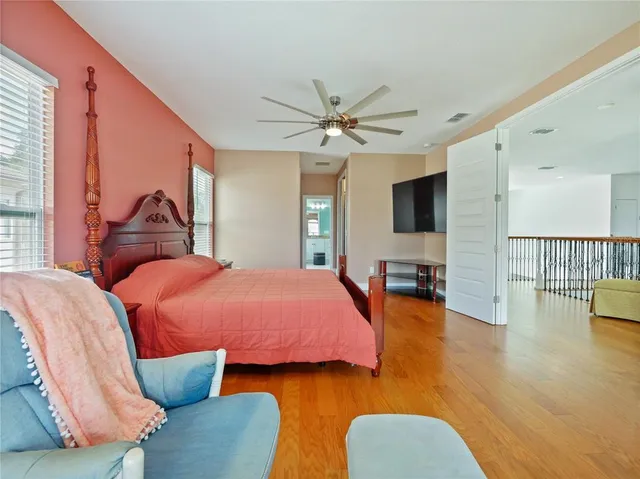 a view of a hallway with bathroom and wooden floor