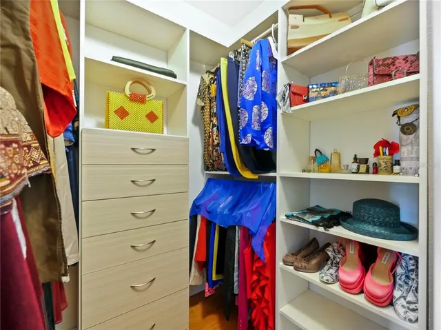 a view of walk in closet with clothes and shoes