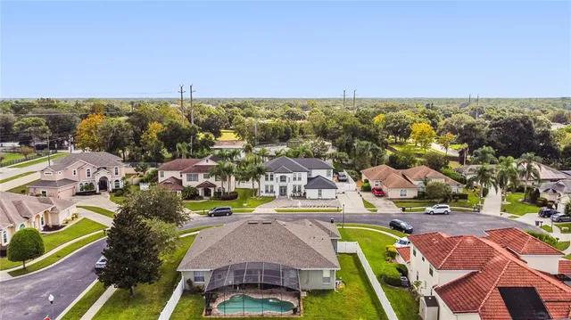 an aerial view of residential houses with outdoor space and trees