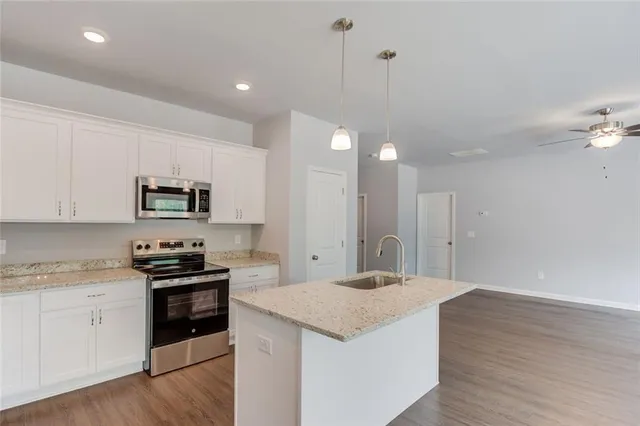 a kitchen with stainless steel appliances granite countertop a sink stove and refrigerator