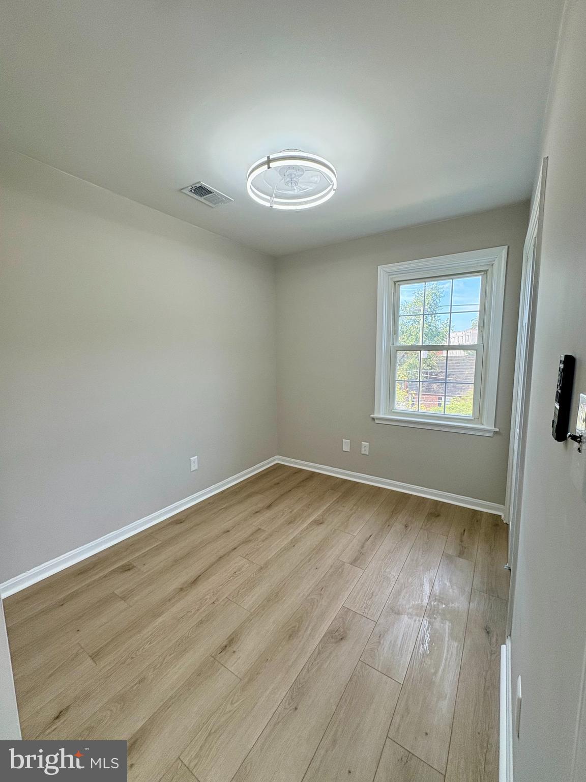 2008 38th Street Southeast, Unit 302 Washington, DC 20020 - Photo 19 of 25 an empty room with wooden floor and windows
