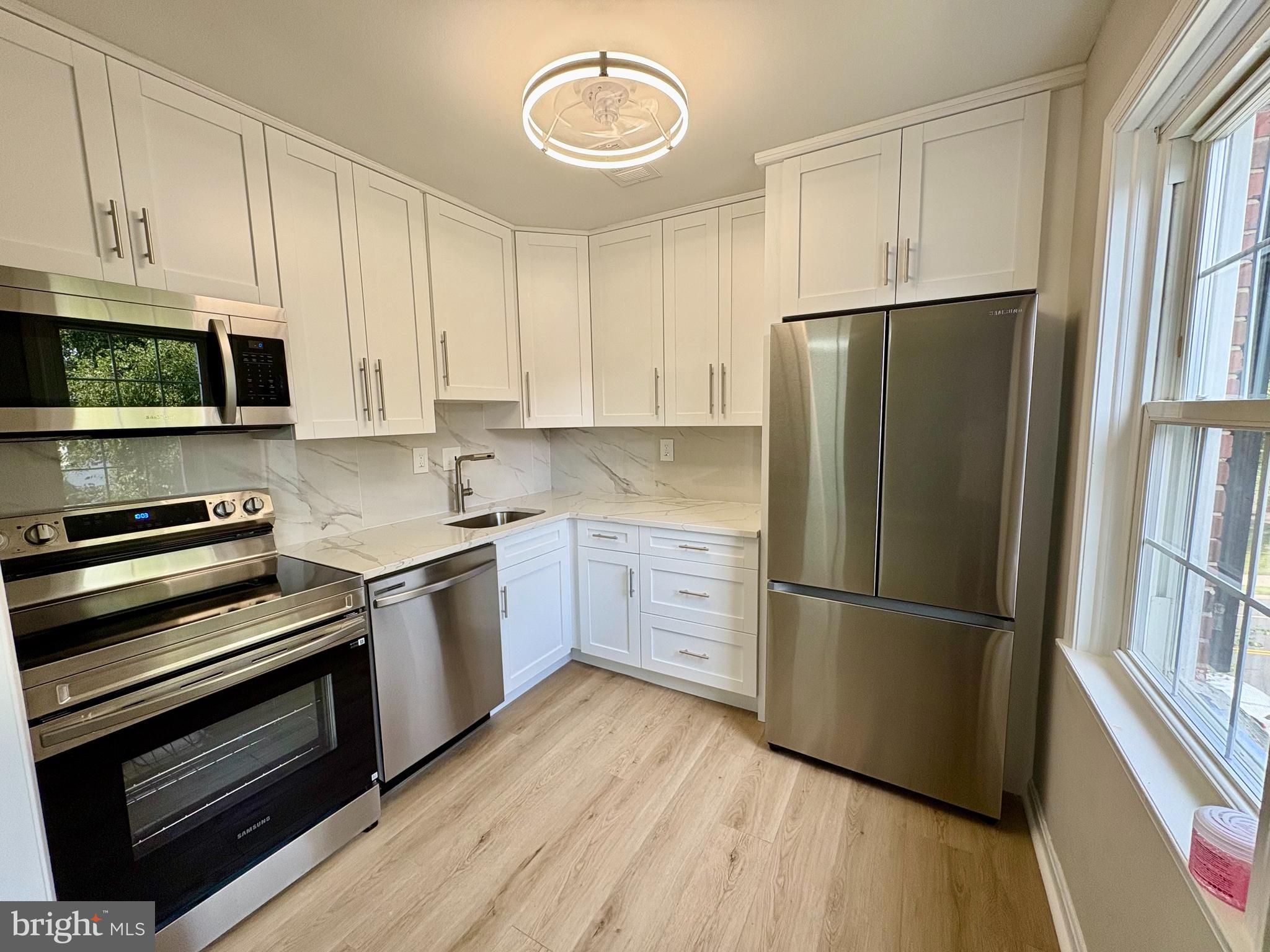2008 38th Street Southeast, Unit 302 Washington, DC 20020 - Photo 7 of 25 a kitchen with a refrigerator stove and wooden cabinets