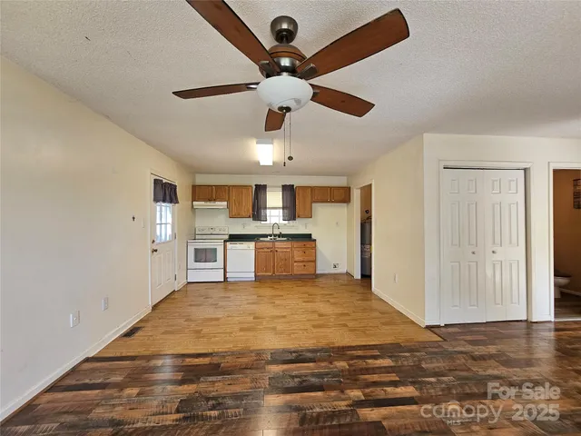 a view of kitchen with kitchen island microwave and wooden floor