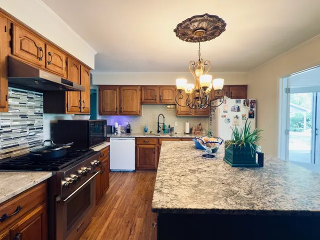 a kitchen with a chandelier and living room