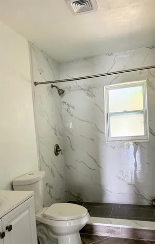 a bathroom with a toilet and a shower