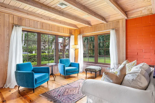 a living room with furniture a flat screen tv and large windows