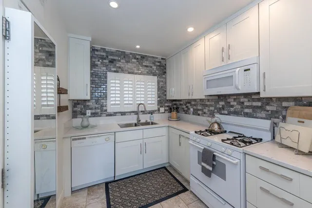 a kitchen with cabinets appliances a sink and a window