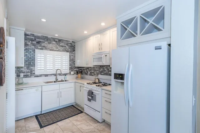 a kitchen with a sink cabinets stainless steel appliances and a window