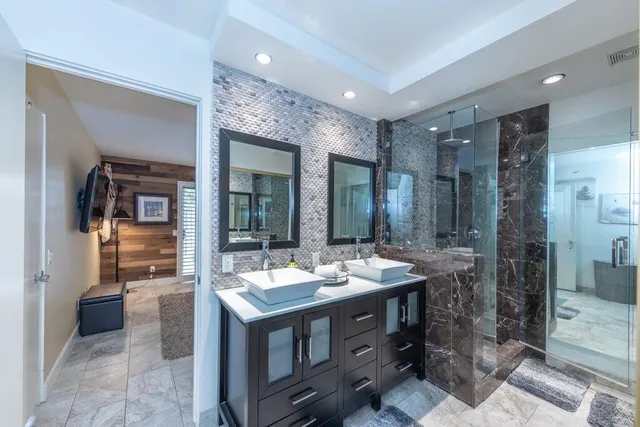 a view of a bathroom with sink shower and mirror
