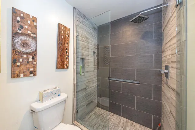 a bathroom with a shower a toilet and a sink