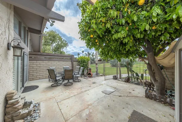 a view of backyard with outdoor seating and trees