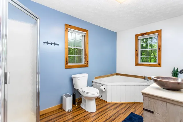 a bathroom with a granite countertop sink and a bathtub