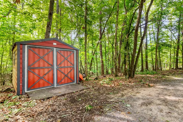 a view of a house with backyard and trees