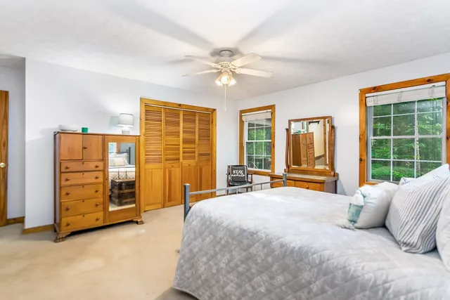 a bedroom with a bed and large windows