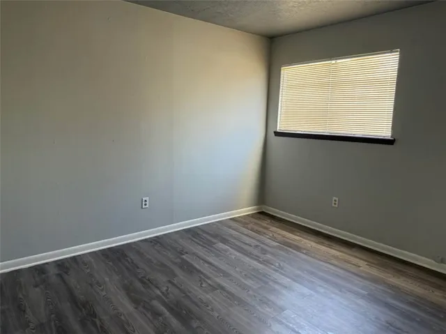 an empty room with wooden floor and a window