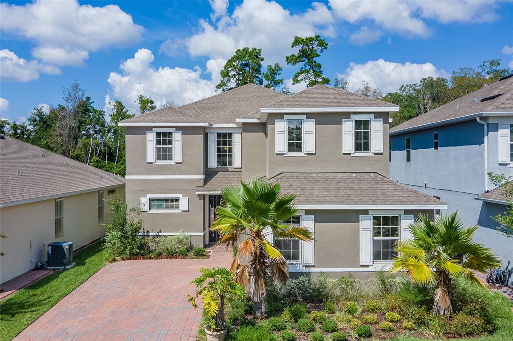 1066 Castlevecchio Loop Orlando, FL 32825 - Photo 1 of 1 a front view of a house with a yard and potted plants