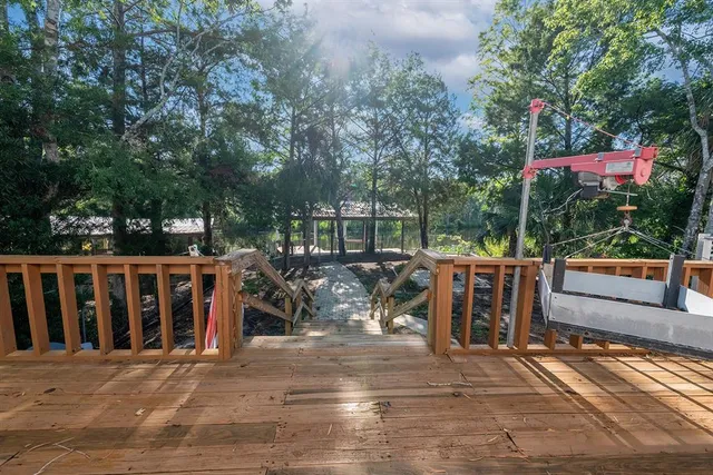 a view of a roof deck with couches and wooden fence