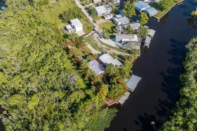 an aerial view of a house with a yard and lake view