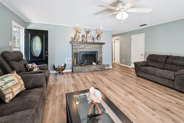 a living room with furniture ceiling fan and a wooden floor