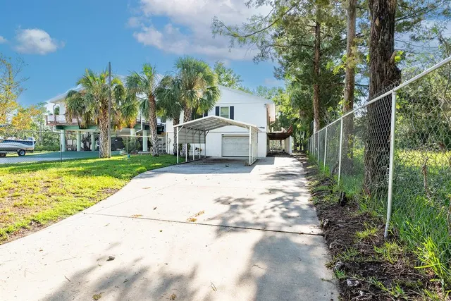 a white house that has a tree in front of it