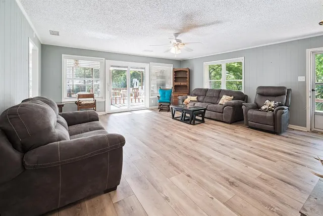 a kitchen with kitchen island a sink a stove a refrigerator and white cabinets with wooden floor