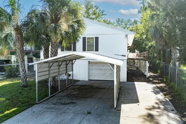 a white house with tall trees