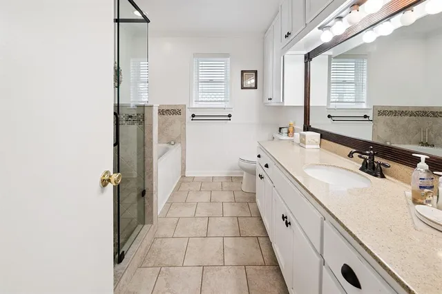 a bathroom with a tub sink a shower and a mirror
