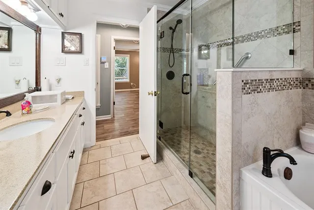 a bathroom with a bathtub a window and a shower