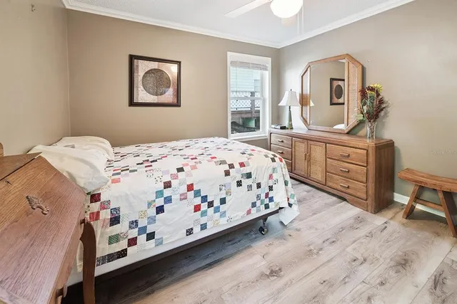 a bedroom with a bed table chair and a window