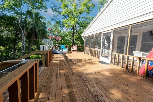 a view of a deck with couches wooden floor and fence