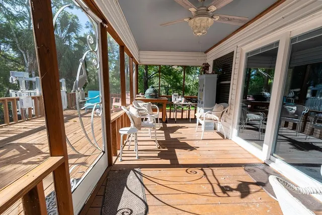 a view of a patio with table and chairs potted plants with wooden floor and fence