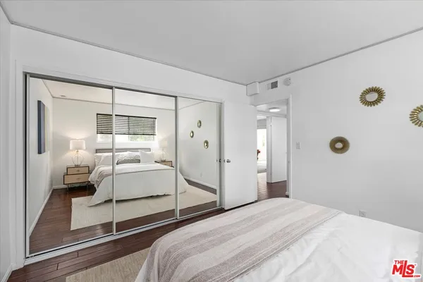 a bedroom with a bed and a large mirror
