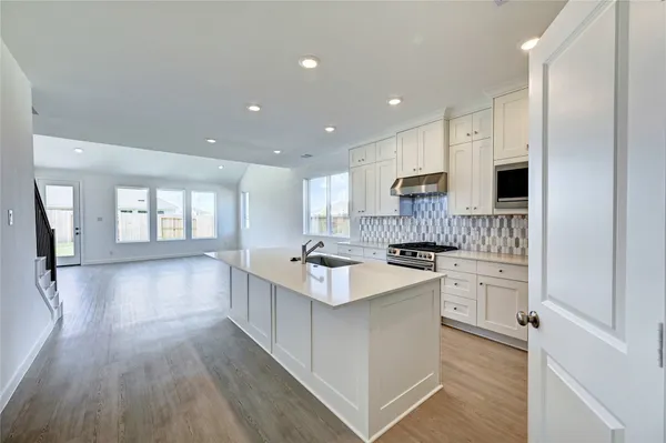a large kitchen with stainless steel appliances kitchen island granite countertop a stove and a sink