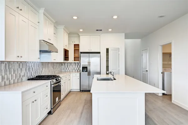 a kitchen with a stove a sink and a refrigerator