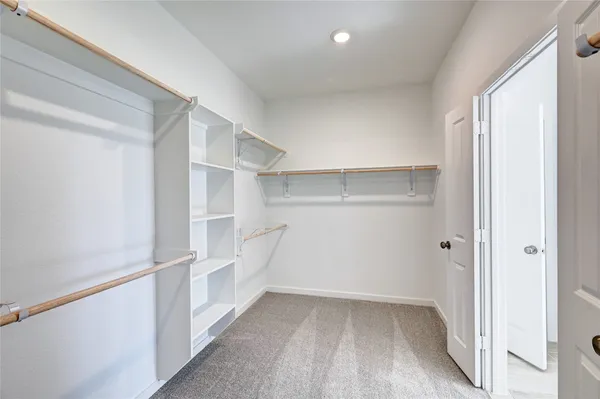 a view of walk in closet with empty racks