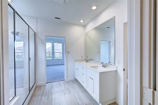 a bathroom with a double vanity sink and mirror with shower