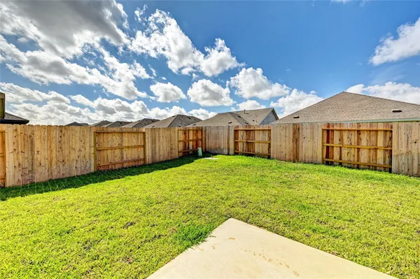 a view of a backyard with table and chairs and wooden fence