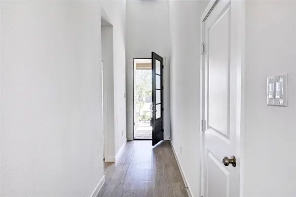 a view of a hallway with wooden floor and closet