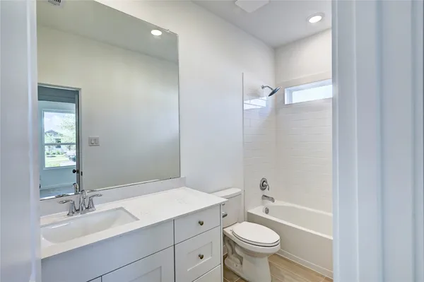 a bathroom with a sink a toilet a mirror and shower